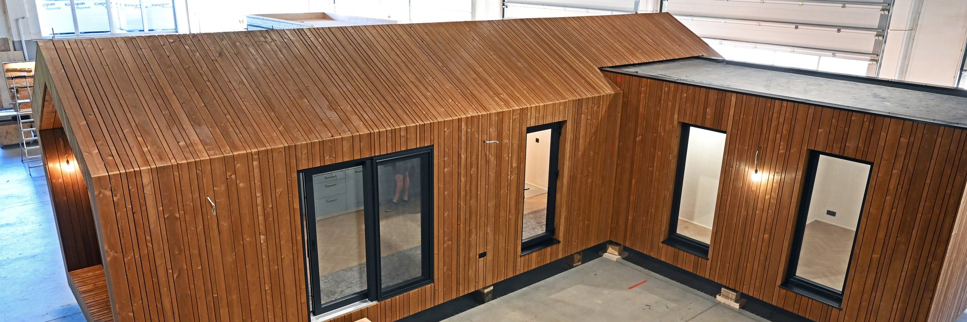 L-f&ouml;rmiges Holzmodul mit thermobehandelter Lattung im Fertigungswerk, aufgest&auml;ndert auf Holzkl&ouml;tzen