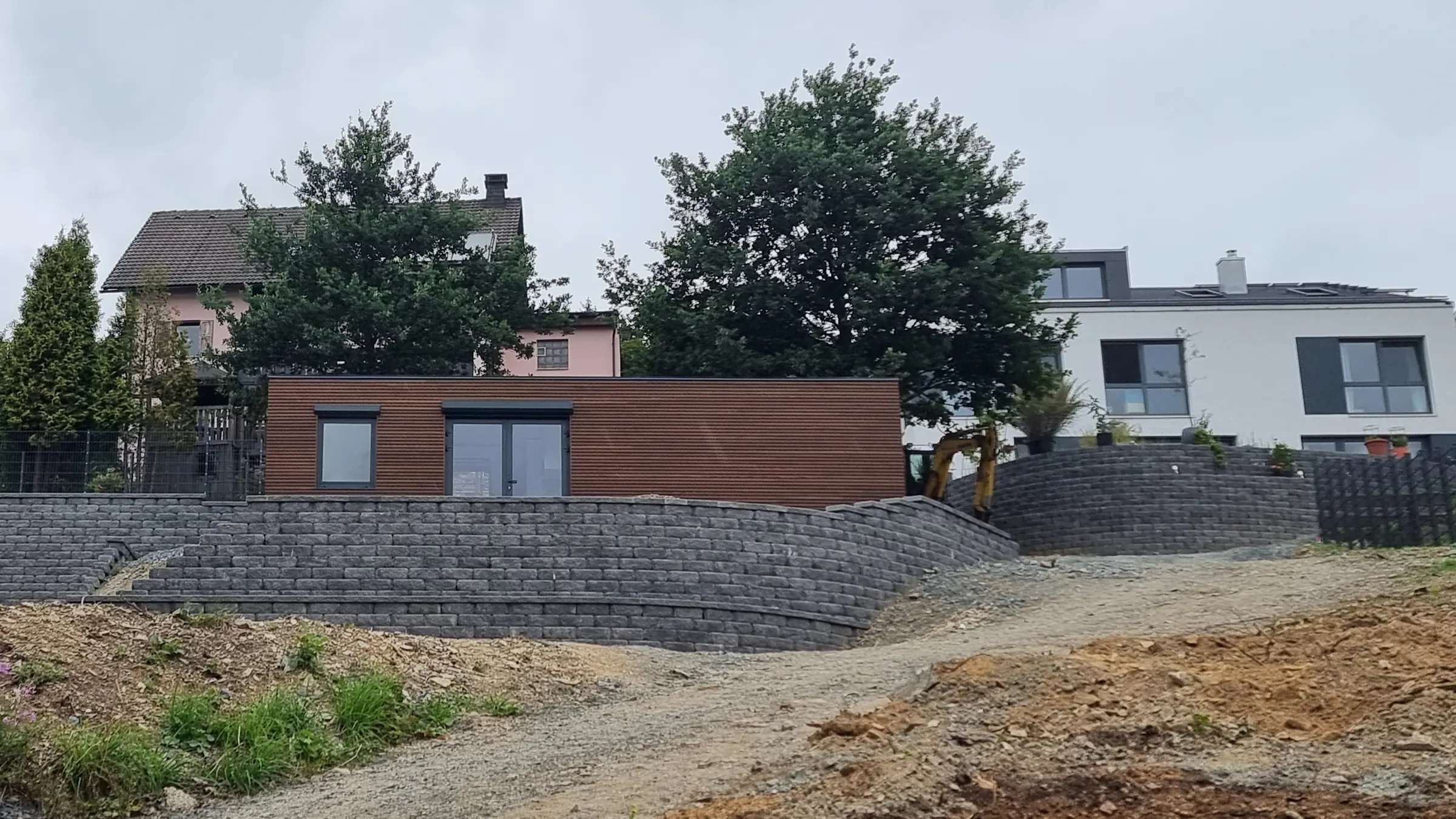 Das Wohnmodul oberhalb der Stützmauer, vom Zufahrtsweg aus gesehen