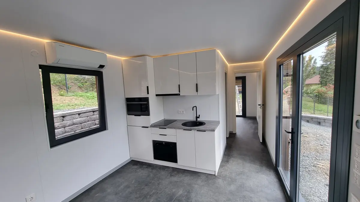 Innenraum des MicroHouse mit Küchenzeile, Backofen, Kochfeld, Spüle und umlaufender Lichtvoute