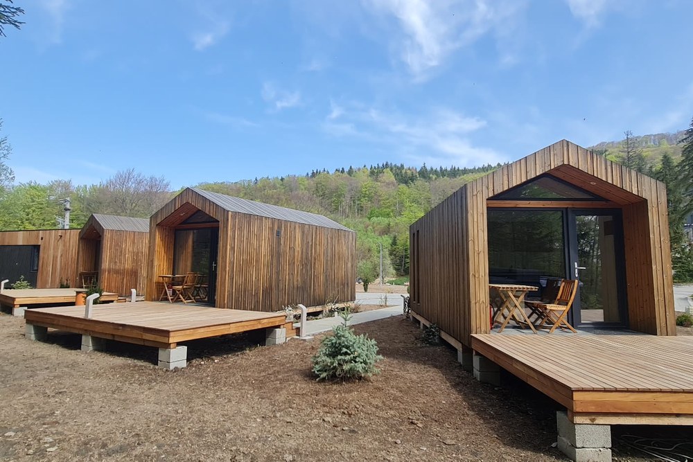 Fertiggestellte Palladium-Module in Holzrahmenbauweise mit Holzfassade, Satteldach und vorgelagerten Holzterrassen