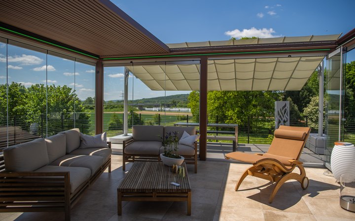 Lamellendach über der Loungeterrasse im LE Außenshowroom, daneben ausgefahrene Markisen