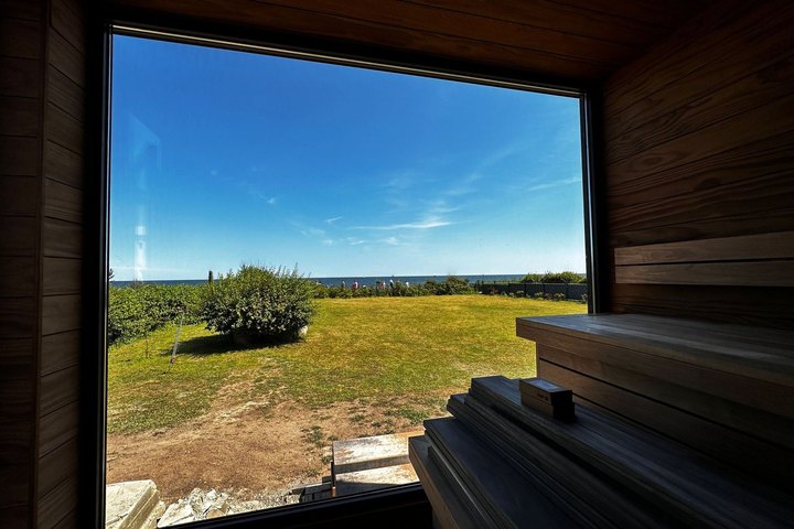 Blick aus der LE GartenSauna durch das Panoramafenster über die Wiese
