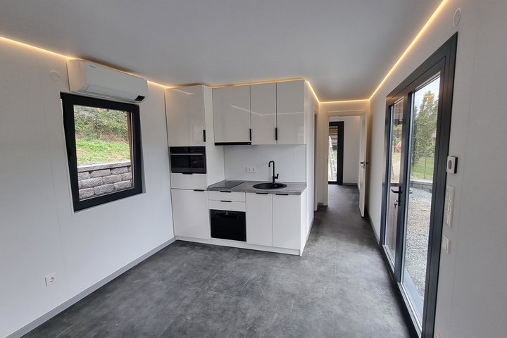 Innenraum des LE MicroHouse mit eingebauter Küchenzeile und umlaufender Lichtvoute