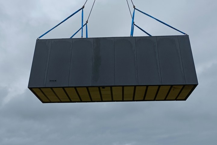 Neun Meter langes LE-SpaCube-Modul am Autokran über dem Grundstück