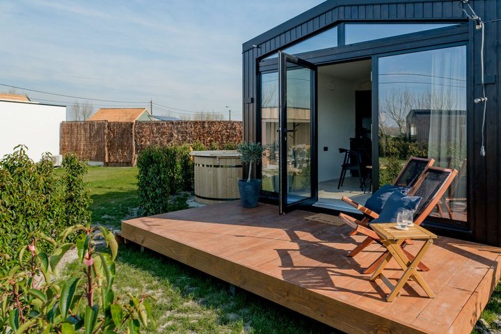 Herstellerreferenz der Palladium Corporation: Ferienhaus in Belgien mit dunkler Fassade, großer Glasfront und Holzterrasse
